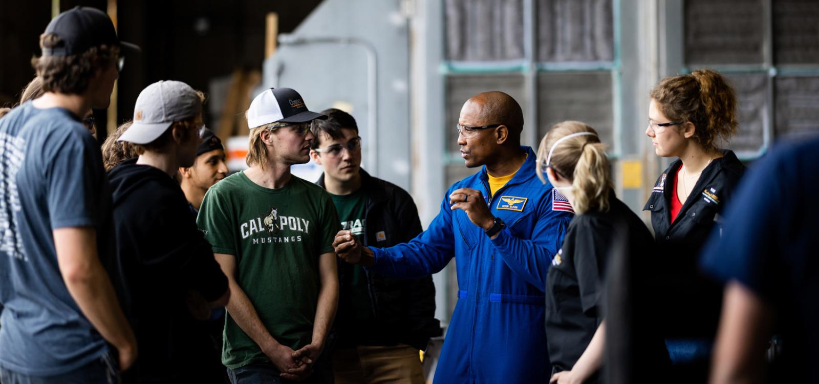 Victor Glover (center) talks to Mustangs at the on-campus Aerospace Engineering Hangar.