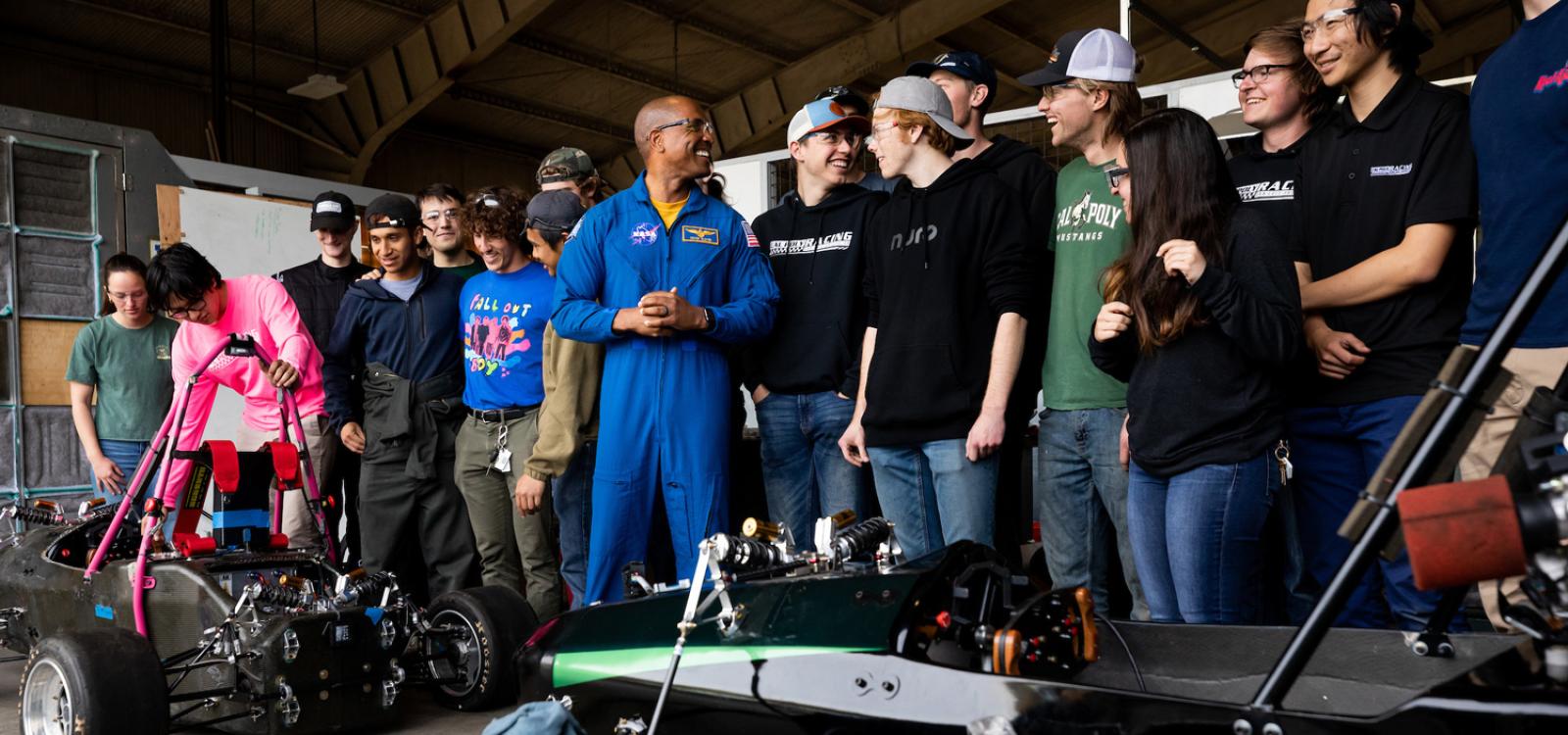 The Cal Poly Racing team shows Captain Victor Glover their vehicles in the on-campus hangar. 