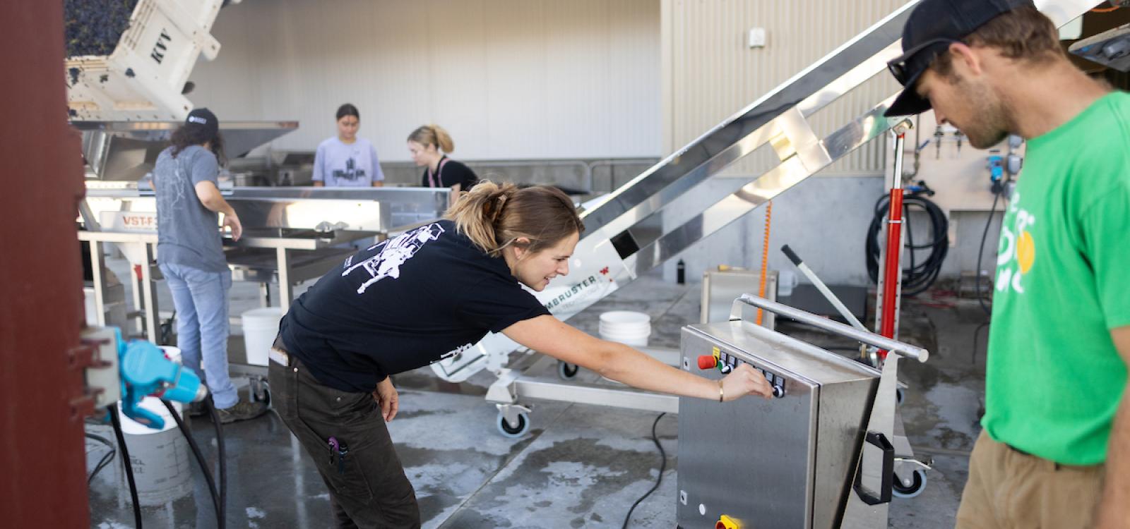 Students Olivia Capiaux and Nolan Maas check part of the machinery.