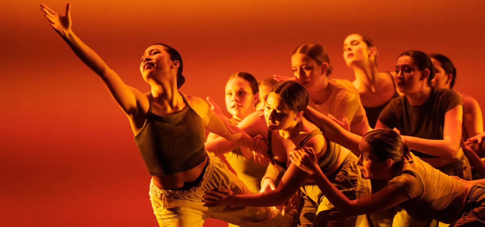 Performers reach during a performance of "Shedding."