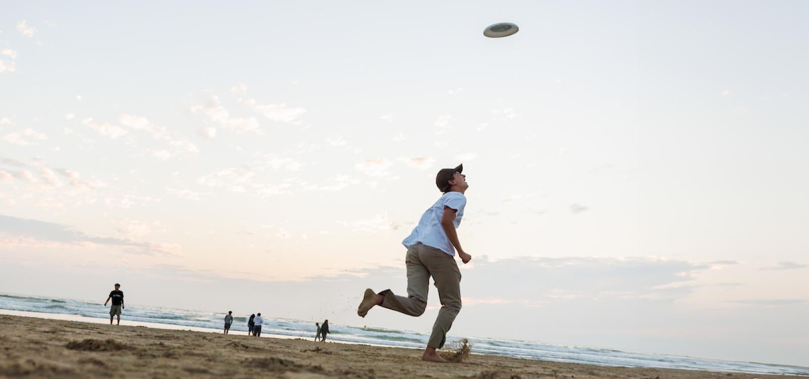 Students play Frisbee during a bonfire at Pismo State Beach.