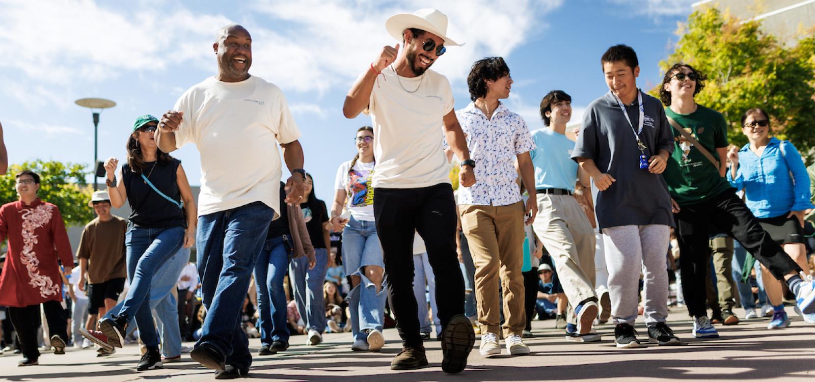 Campus community members smile and dance during CultureFest, an annual celebration of diversity through culture, food, and community that happens in October. 