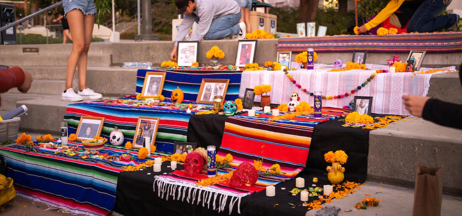 An ofrenda in UU Plaza, bathed in the soft glow from the sunset, featured photographs of loved ones, marigolds, candy and skulls.
