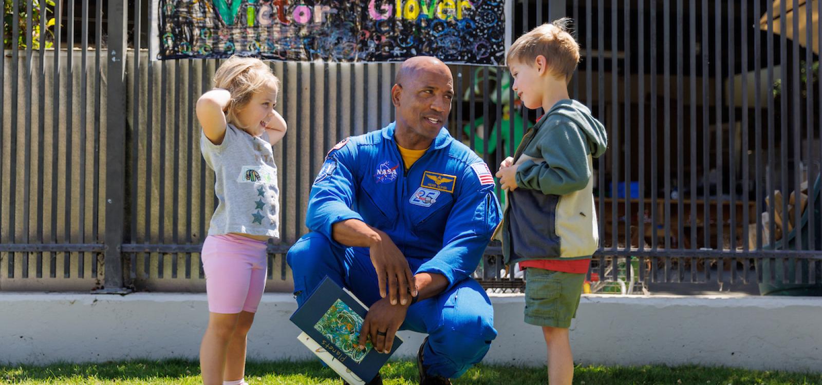 Victor Glover speaks with two children at the Preschool Learning Lab on campus.