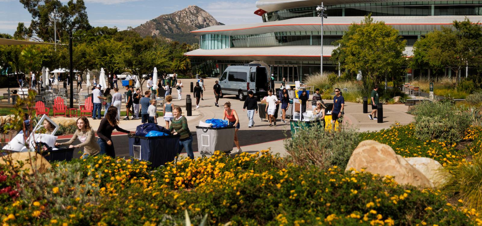 Students, family and friends move belongings in front of the Performing Arts Center during the Fall Mustang Move-In.