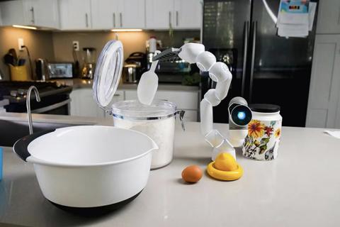 A robotic arm scooping ice on a countertop.