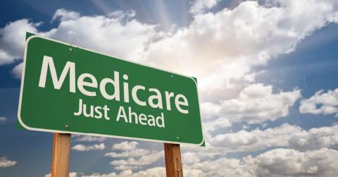 A green highway sign that reads “medicare just ahead.”