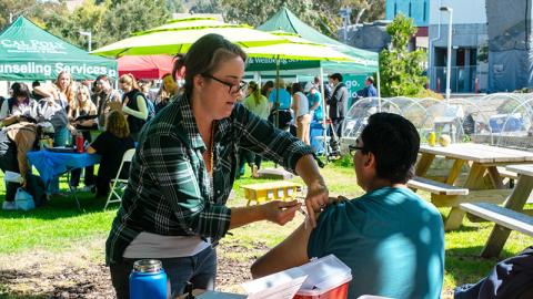 A student getting a vaccine at a CH&W health fair.