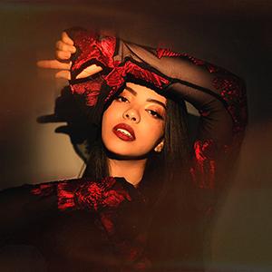 A headshot of Lucía wearing a black and red blouse.