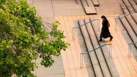 An image of a person walking on campus.