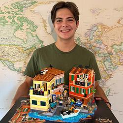 Alex Sahli holding a demo of his 3,251-piece Italian Riviera Lego build.