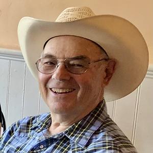A headshot of Bob McCorkle in a blue flannel shirt and cowboy hat.