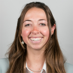 A headshot of Olivia Halter in a gray blazer and white blouse.