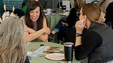 Attendees at an OUDI training on campus in Fall 2024 sitting around circle tables in PAC lobby.