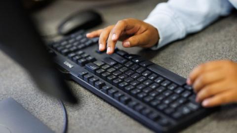 Hands using a computer keyboard.