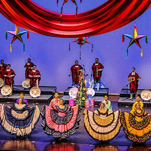Campana Sobre Campana performing on stage in traditional folklórico and mariachi clothing.