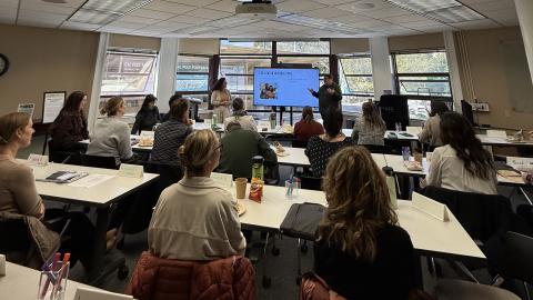 A group of people watch a presentation in a classroom