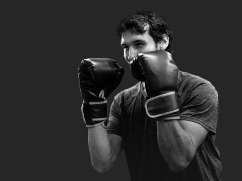 A black-and-white image of a boxer with his gloves up.