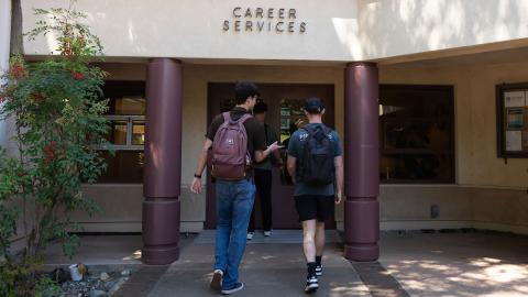 Two students walking into the Career Services building.