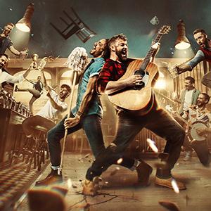 The Choir of Man performing in a bar-like setting on stage.