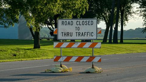 A sign that says "Road Closed to Thru Traffic" in the middle of a road.