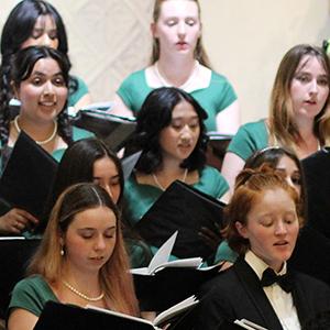 Choir students singing during a performance.