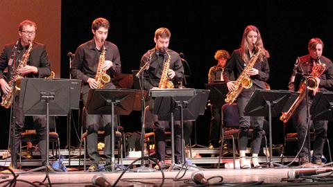 Members of the Cal Poly jazz ensembles playing instruments on stage.