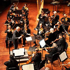SLO Symphony performing on stage with maestro Andrew Sewell.