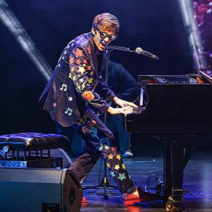 Sir El Tom playing the piano onstage.
