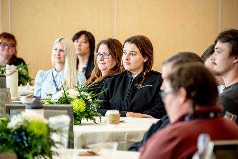 Students sitting at a table listening to a speaker at the Women in Maritime Leadership Conference.