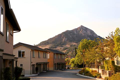 Townhomes and trees in the Bella Montana housing development with a mountain in the background.
