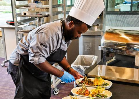 Chef Arthur Dulin plates Thai red curry catfish with okra and crispy coconut rice cakes, along with a catfish pomelo salad garnished with crispy okra, during the Pacific regional portion of the NACUFS culinary competition.