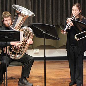 Students playing instruments on stage.