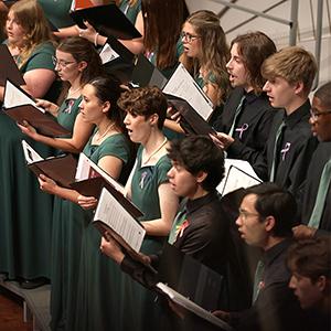 Choir members singing on stage.