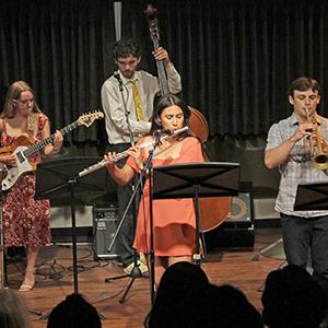 Members of the Cal Poly Jazz Combos playing their instruments on stage.