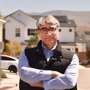 Hamed Ghoddusi standing in front of a housing development.