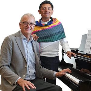 Rafael Montero, tenor, and John Sloboda, piano, in front of a piano.