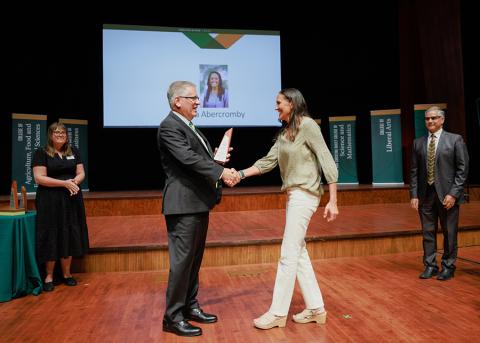 A Cal Poly community member accepting an award from President Armstrong during a previous Convocation.