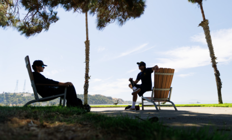 Two people sitting in Adirondack chairs and talking at Cal Poly Maritime Academy.