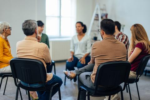 A group of faculty members sitting in a circle and discussing advising.