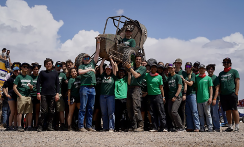 The Cal Poly Racing Team holding up their Baja Buggy.