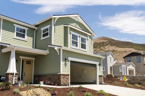 A new Vista Meadows home with a hill and blue sky in the background.