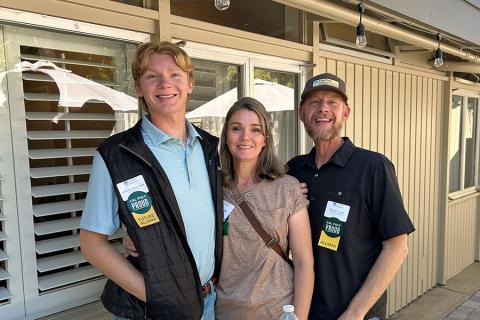 Two Cal Poly alumni parents posing for a photo with their current Mustang.