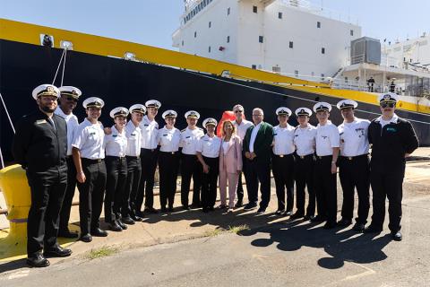 Cadets in uniform standing with Gov. Gavin Newsom, California State University Chancellor Mildred García, Cal Poly President Jeffrey D. Armstrong and other leaders in front of the Training Ship Golden Bear.
