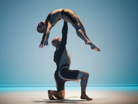 Two Circa company members doing a lift on stage.