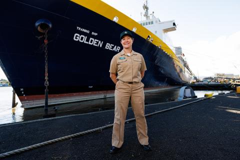 Capt. Samar Bannister standing in front of a docked Training Ship Golden Bear.