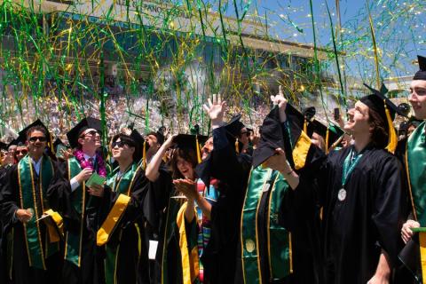 Cal Poly students celebrating graduation as streamers fly through the air.