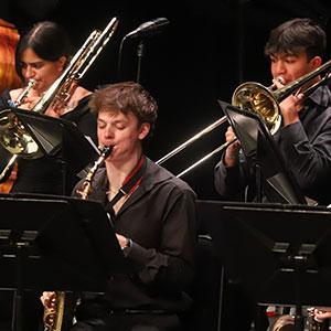Students playing trombones and saxophones. 