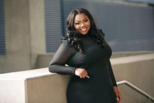 First-year psychology student Nailah DuBose, smiling in a black dress