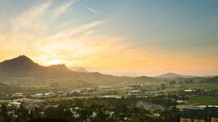 A sunset behind Bishop Peak illuminates the Cal Poly campus